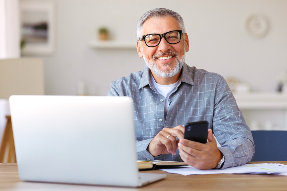 man smiling at computer wearing glasses
